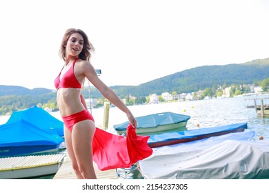 Beautiful Girl With Red Bikini On Jetty By A Lake. High Quality Photo