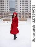 beautiful girl in a red coat and red beret in winter