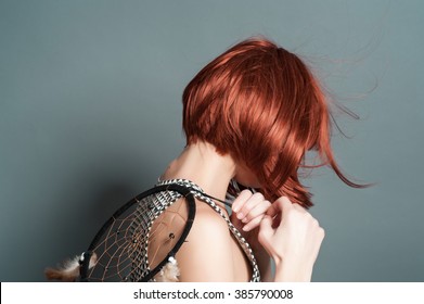 Beautiful Girl With Red Hair In The Studio Holding A Dream Catcher, Back