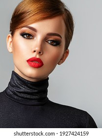 Beautiful Girl With Red Lips And Short Hair. Pretty Face Of An Young Sensual Woman. Closeup Portrait Of A Model With Bright Makeup On A Face. Attractive Female Posing At Studio  In Black Closes.    