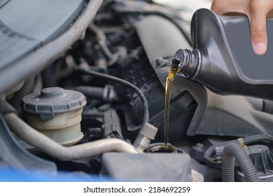 beautiful girl Refueling and pouring oil quality into the engine motor car Transmission and Maintenance Gear .Energy fuel concept. car maintenance
