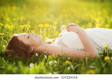 Beautiful girl is relaxing lying on the grass in the garden