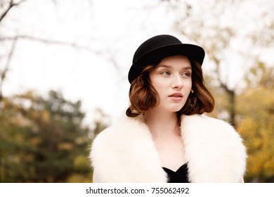 Beautiful girl in retro clothes on a blurred background of autumn park