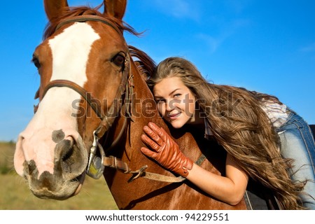 Beautiful girl riding a horse against blue sky