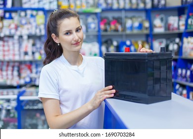 Beautiful Girl Saleswoman Offers The Best Battery For Car In An Auto Parts Store