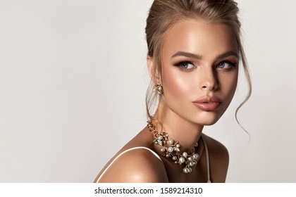 Beautiful girl with set jewelry .   Fashion woman in a necklace and earrings . Beauty  ,   cosmetology and accessories. 