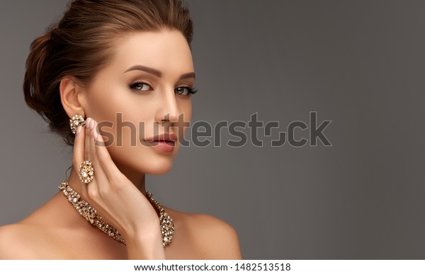 Beautiful girl\
with set jewelry .   Woman in a necklace with a ring, earrings and\
a bracelet. Beauty and\
accessories.