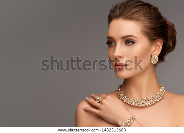 Beautiful girl\
with set jewelry .   Woman in a necklace with a ring, earrings and\
a bracelet. Beauty and\
accessories.
