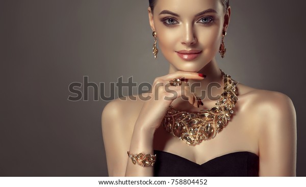Beautiful girl
with set jewelry .   Woman in a necklace with a ring, earrings and
a bracelet. Beauty and
accessories.
