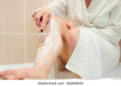 beautiful girl shaving her legs using a razor while taking shower in bathroom - Shutterstock ID 662606626