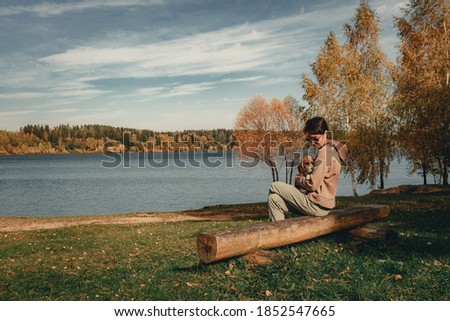 Similar – Man sitting by the river in fall