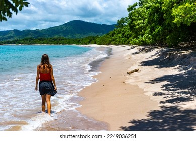 a beautiful girl in a short skirt walks on the famous conchal beach on the pacific coast of Costa Rica; a paradise beach with turquoise water and green hills in the background	
 - Shutterstock ID 2249036251