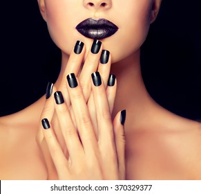 Beautiful girl showing black manicure nails . makeup and cosmetics