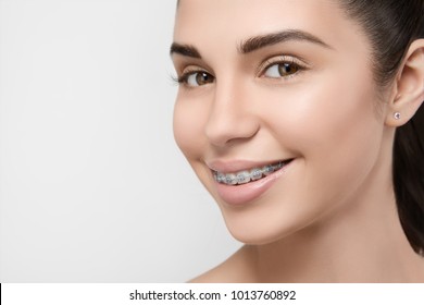 Beautiful Girl Smiling Looking On A Camera, White Teeth With Braces. Dental Care. Beauty Woman Smile With Orthodontic Accessories. Cosmetic Dentistry, Orthodontics Treatment. 