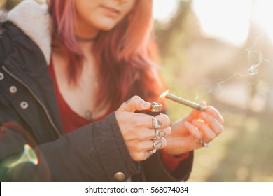 beautiful girl smoking weed on a hike - Shutterstock ID 568074034