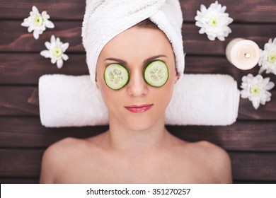 Beautiful Girl At Spa Salon With Cucumbers On Eyes