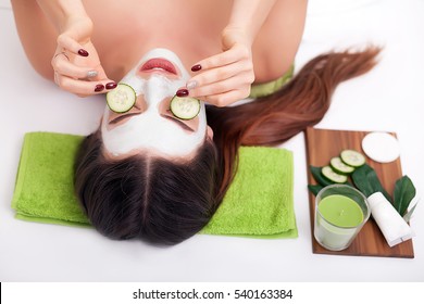 Beautiful Girl At Spa Salon With Cucumbers On Eyes