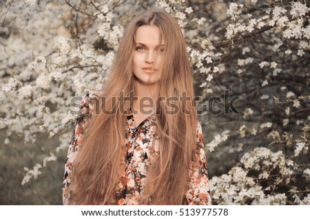 beautiful girl in spring blossoming garden