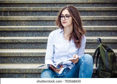 Beautiful Girl, A Student In Glasses Reads A Book On The Stairs. Education, Training. Indian College