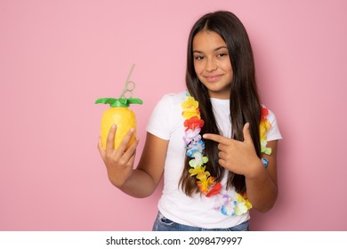 Beautiful Girl In Summer Outfit Holding Pinapple Juice Isolated On Pink Background.