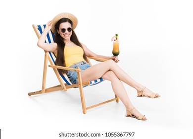 beautiful girl in sunglasses resting on beach chair with cocktail, isolated on white