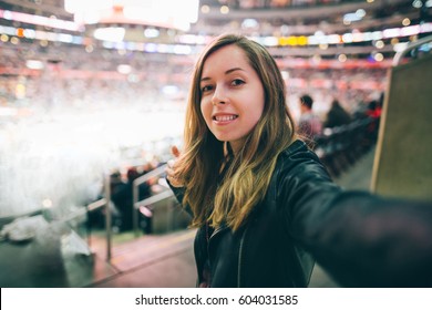 Beautiful Girl Supporter Taking Selfie Self-portrait While Watching Basketball Game At The Stadium