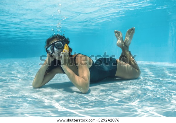 美しい女の子が水中でスマートフォンに電話する の写真素材 今すぐ編集