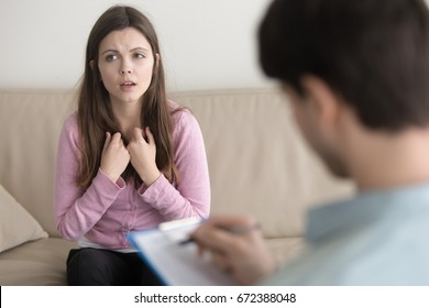 Beautiful girl telling to psychotherapist about her troubles, doctor writing down some notes. Female patient explaining purpose of a visit to psychologist while doctor filling in her medical card - Shutterstock ID 672388048