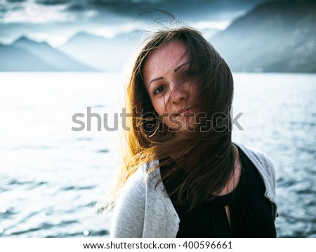Beautiful girl with tousled hair on the background of the Bay in Montenegro