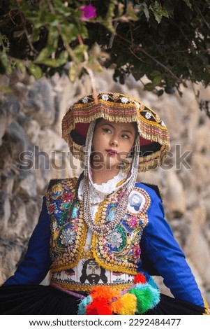 Beautiful girl with traditional dress from Peruvian Andes culture. Young girl in Ollantaytambo city in Incas Sacred Valley in Cusco Peru.