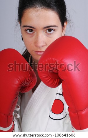 beautiful girl training combat with boxe gloves, studio photo