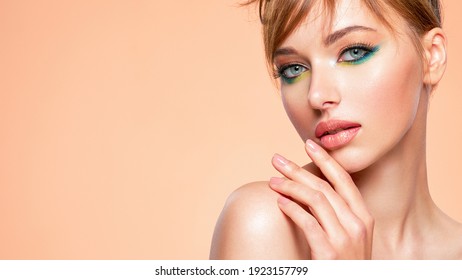 Beautiful girl with trandy makeup. Face of an young girl close-up with a green color makeup. Stylish makeup.