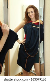 Beautiful Girl Trying Dress Near Mirror In Room