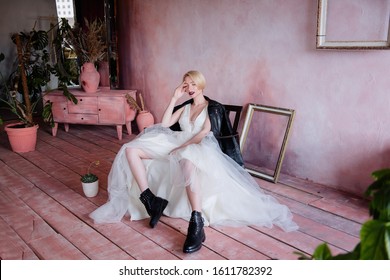 Beautiful Girl In An Unusual Image Of The Bride. The Bride In A Delicate Dress And Rude Black Boots And A Black Leather Jacket.