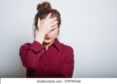 Beautiful Girl Upset Covered Her Face, Isolated On A Gray Background