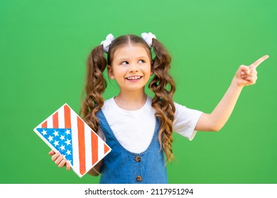 A Beautiful Girl With A US Flag On A Book Points To The Side. Learning American English. Getting An Education In The USA. Private School In America.