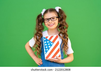 A Beautiful Girl With A US Flag On A Book Points To The Side. Learning American English. Getting An Education In The USA. Private School In America.