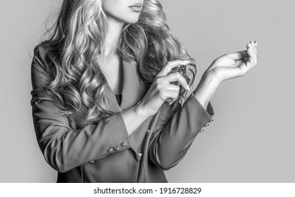 Beautiful girl using perfume. Woman with bottle of perfume. Woman presents perfumes fragrance. Perfume bottle woman spray aroma. Woman holding a perfumes bottle. Black and white.