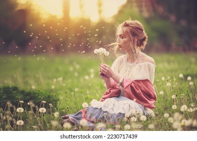 beautiful girl in a vintage look sits at sunset in a field of dandelions and blows on dandelions, May, warm, spring - Powered by Shutterstock