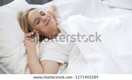 Beautiful girl waking up in morning, stretching herself after healthy sleep