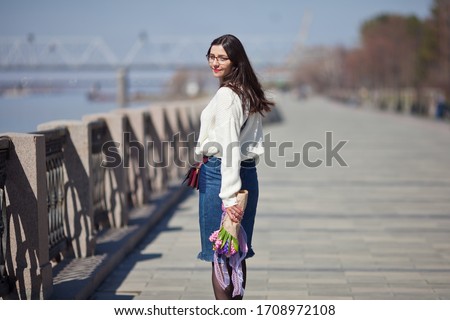 beautiful girl walks with a bouquet of spring flowers along the promenade, a bouquet of hyacinths