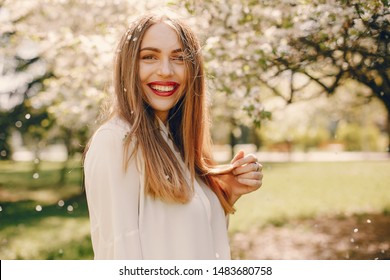 Beautiful girl in a white blouse. Woman in a summer park