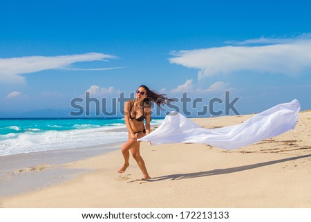 Beautiful Girl With White fabric on The Beach. Travel and Vacation. Freedom Concept.