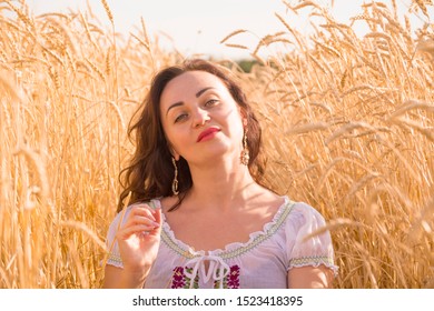 Beautiful Girl In A White Peasant Blouse In The Field Among The Wheat Ears