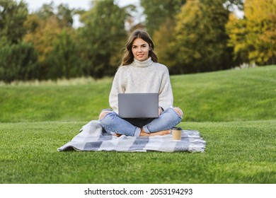 Beautiful girl working at MacBook Pro in the park