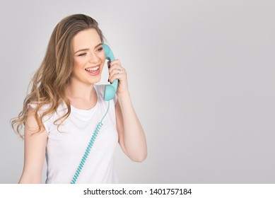 Beautiful Girl, Young Adult, Smiling And Screaming Over The Phone, Holding Blue Land Line Phone Telephone Headset, Horizontal Isolated On White, Blond Model