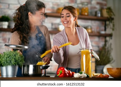 Beautiful girlfriends cooking in the kitchen. Best friends preparing healthy home made meal in the kitchen.  - Powered by Shutterstock
