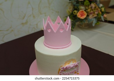 Beautiful girlish birthday cake with pink mastic crown, bow, inscription name Maria. One year old or five years old birthday cake, sweet dessert treat