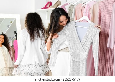 Beautiful Girls Choosing Clothes For High School Prom In Shop