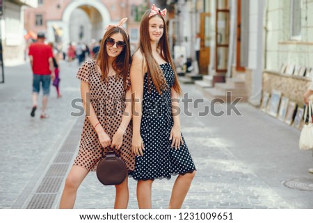 Beautiful girls dressed in retro dress. A preety ladies with a tape on her head. Famale in a summer city